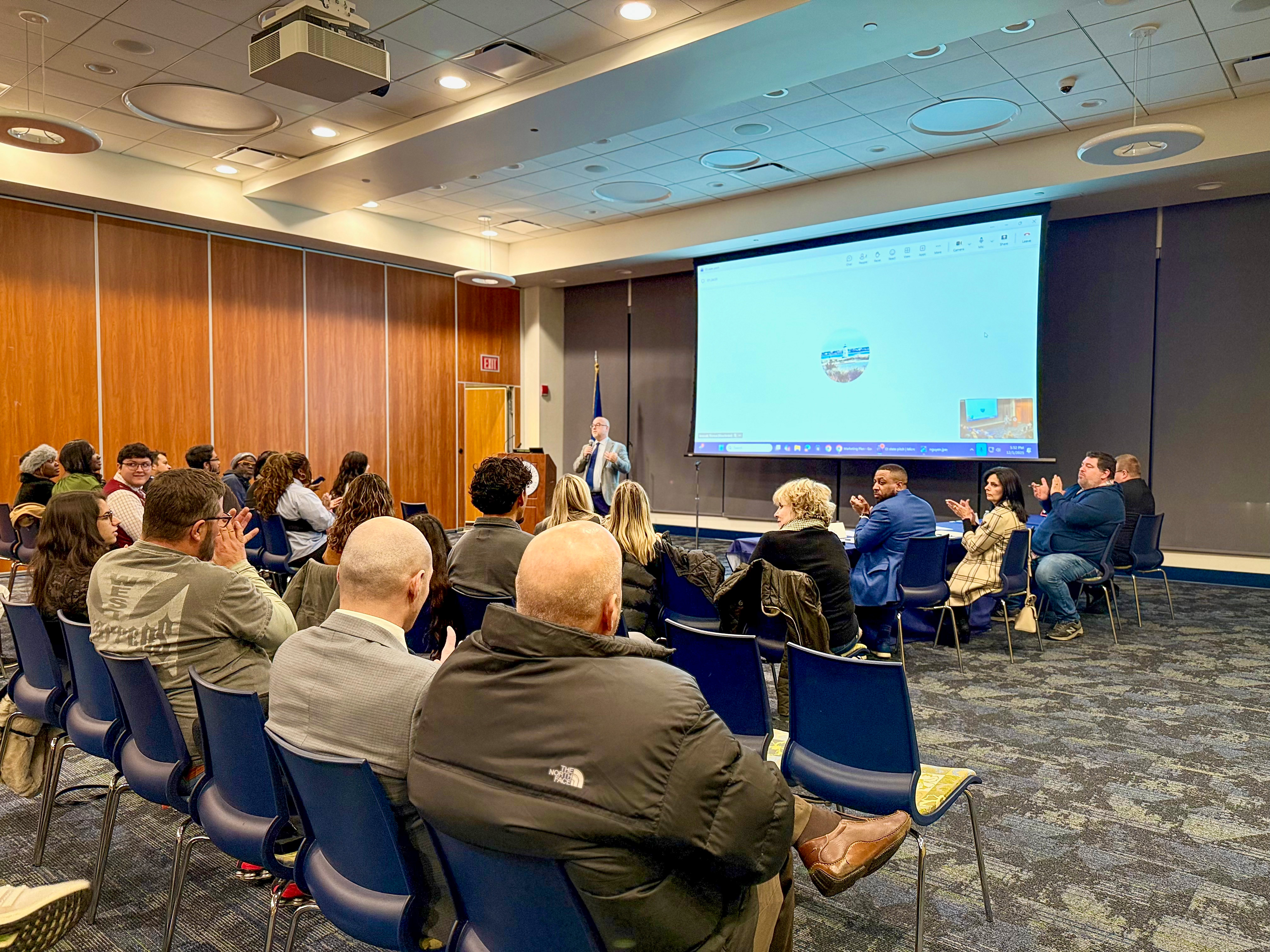 Student speaking at a podium during a CT State event, with attendees seated in the background.