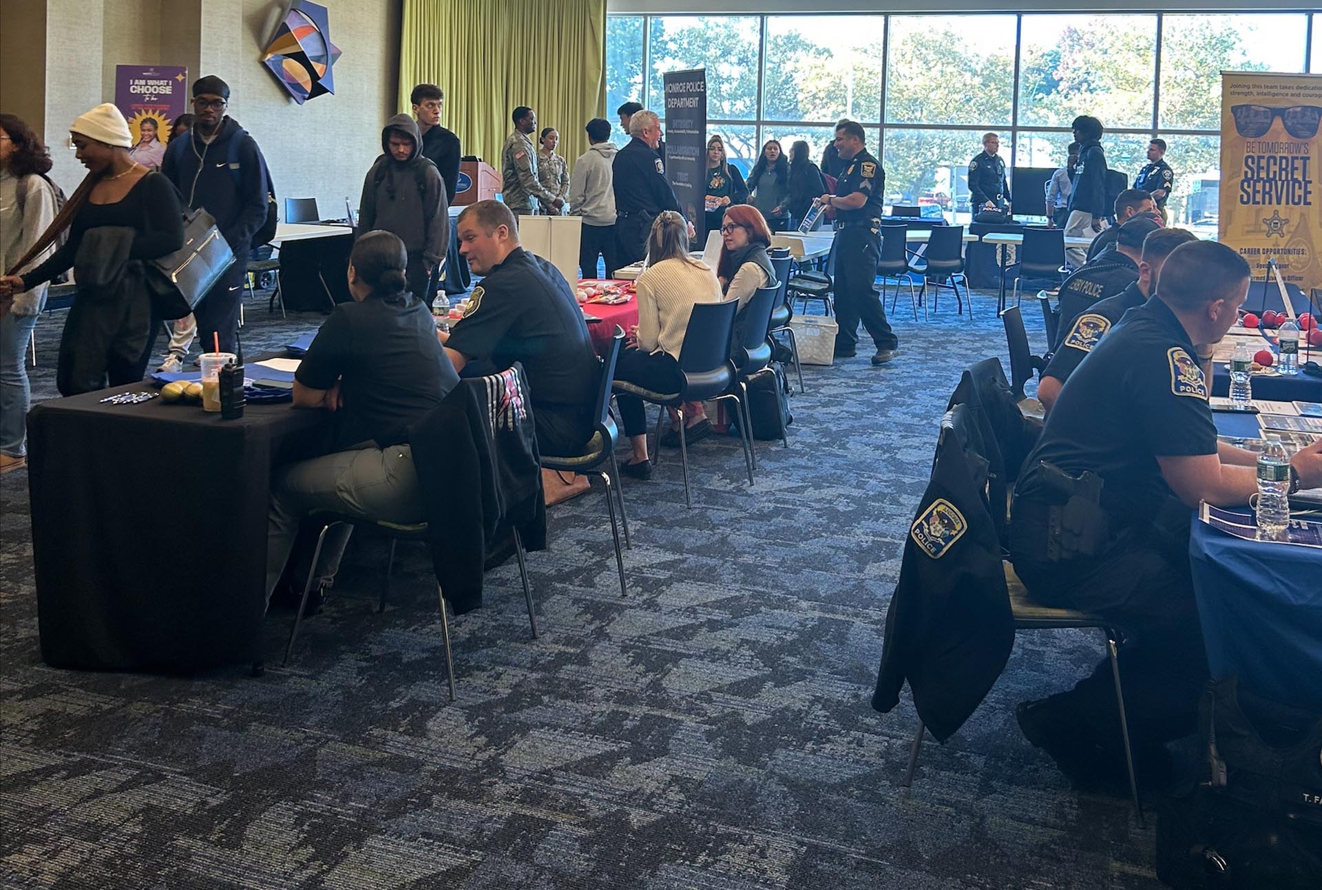 A photo of an event with people browsing different tables of vendors