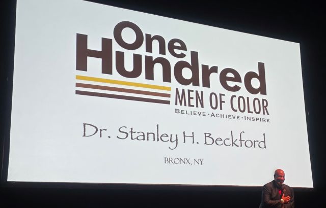 Man on stage in front of screen