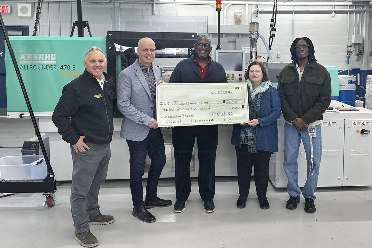 Five people hold a replica of a $13,500 check