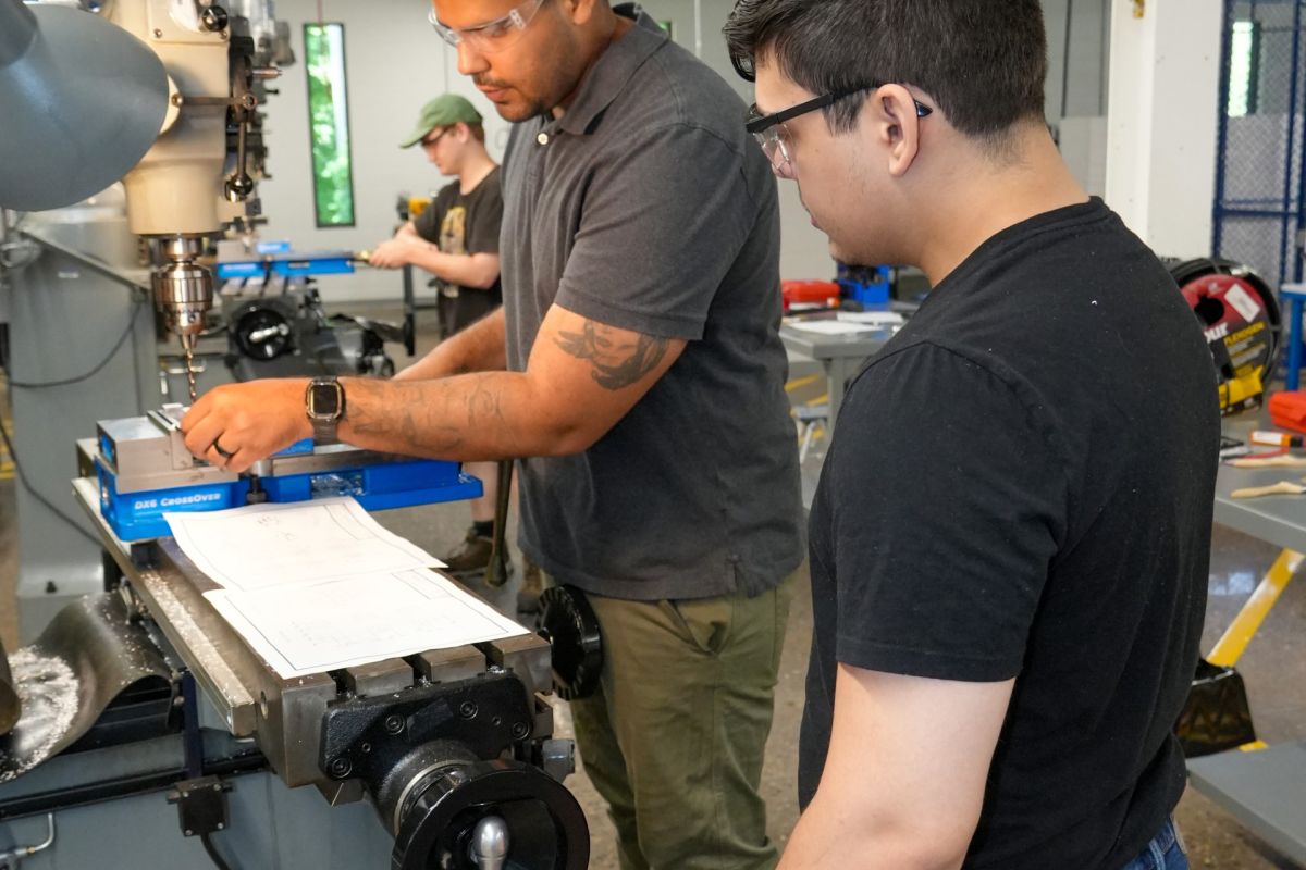 Manufacturing students work on a milling machine