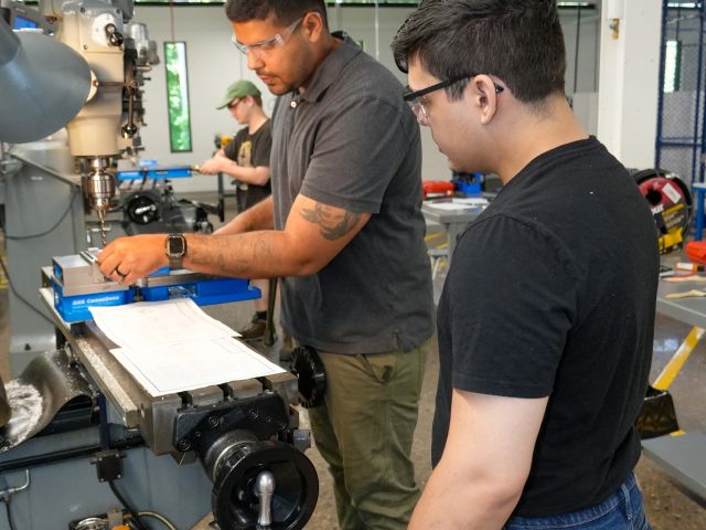 Manufacturing students work on a milling machine
