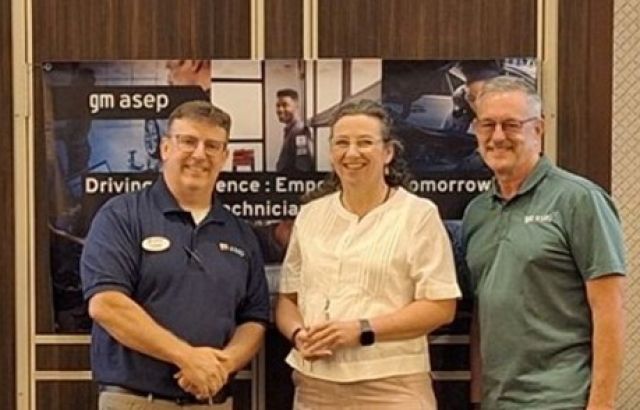 2 men and a woman stand together and smile into the camera