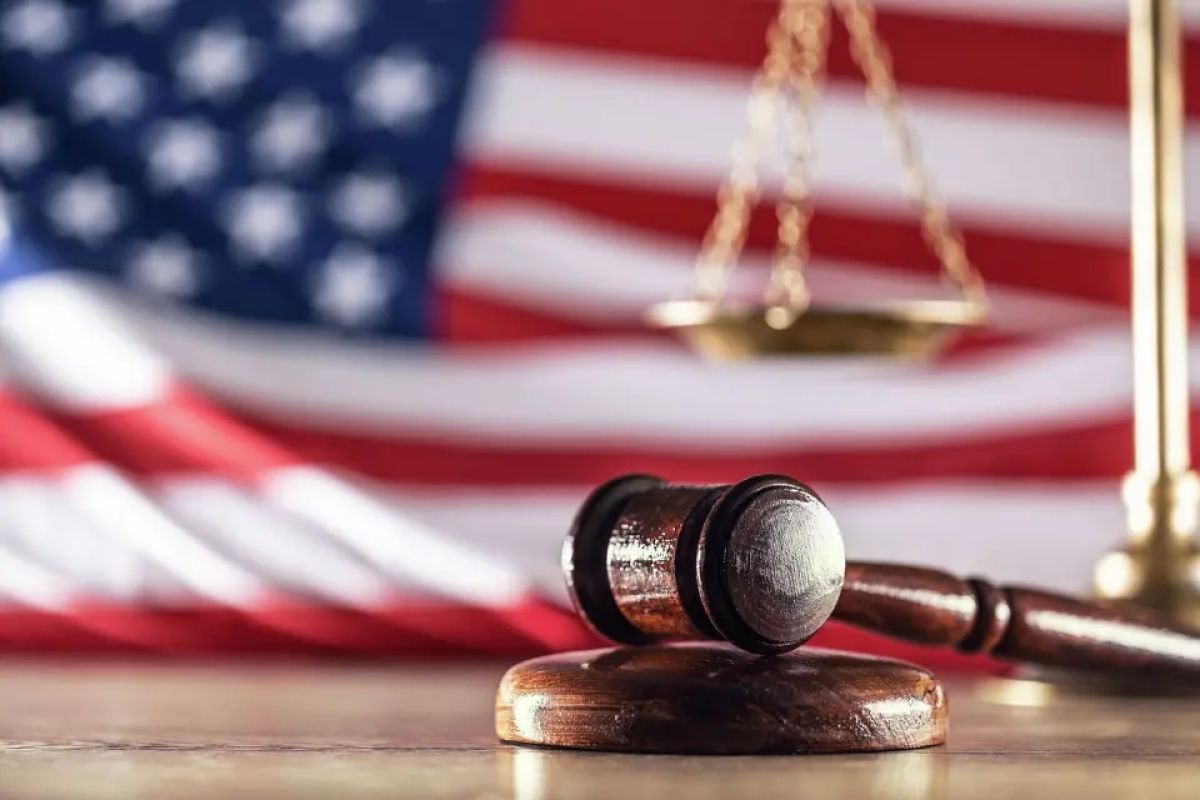 Gavel and scales with a US flag in the background as symbols of a jurisdiction.