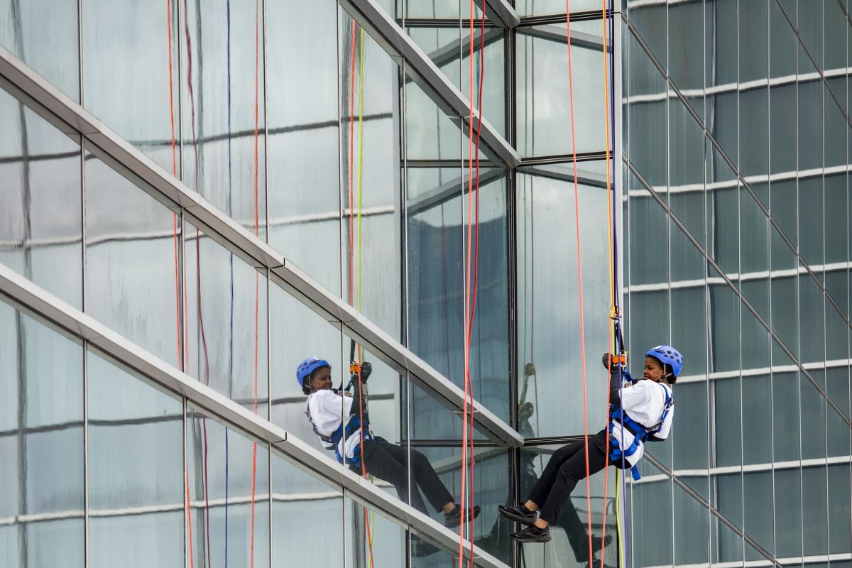 Person with gear slides down the side of a building.