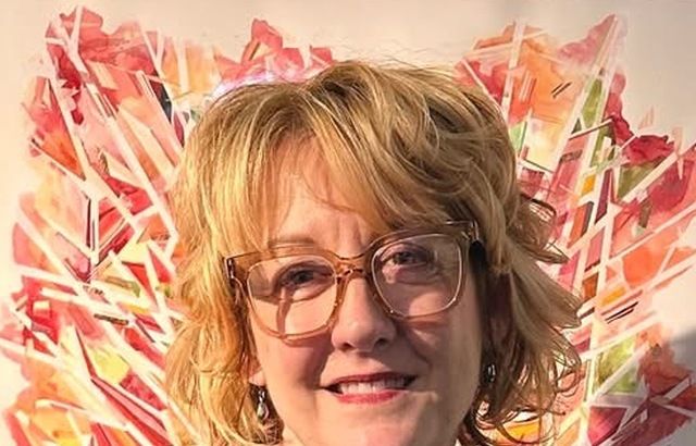 woman smiling in front of a painting