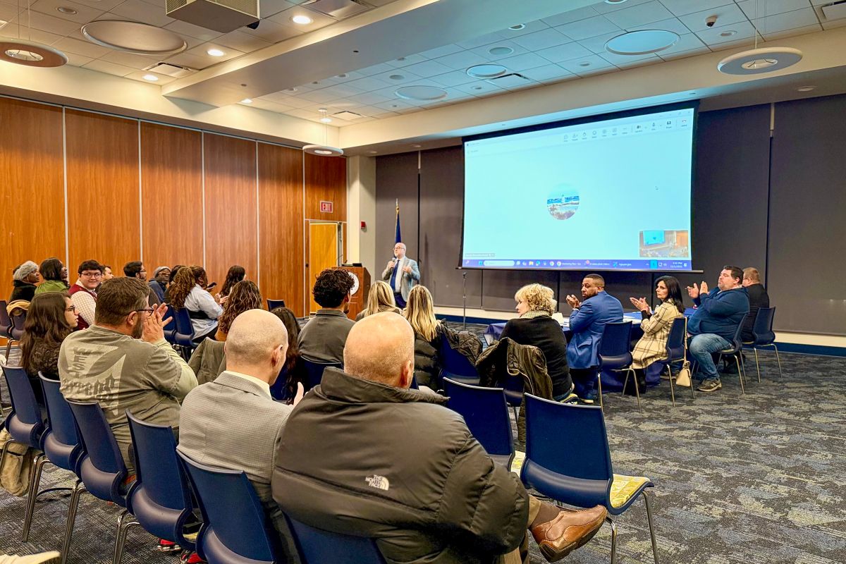 Student speaking at a podium during a CT State event, with attendees seated in the background.