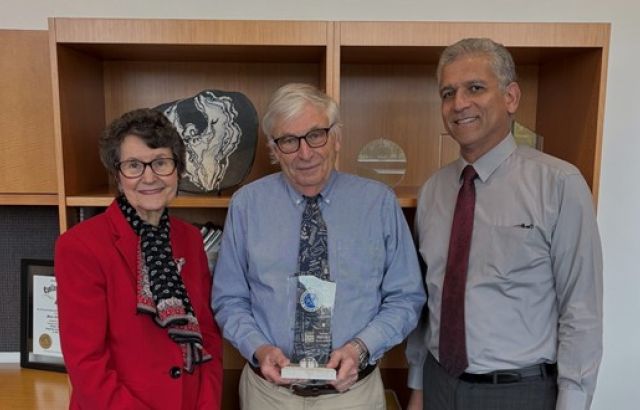 Jim Sherrard stands and smiles at the camera with the president and dean of academics