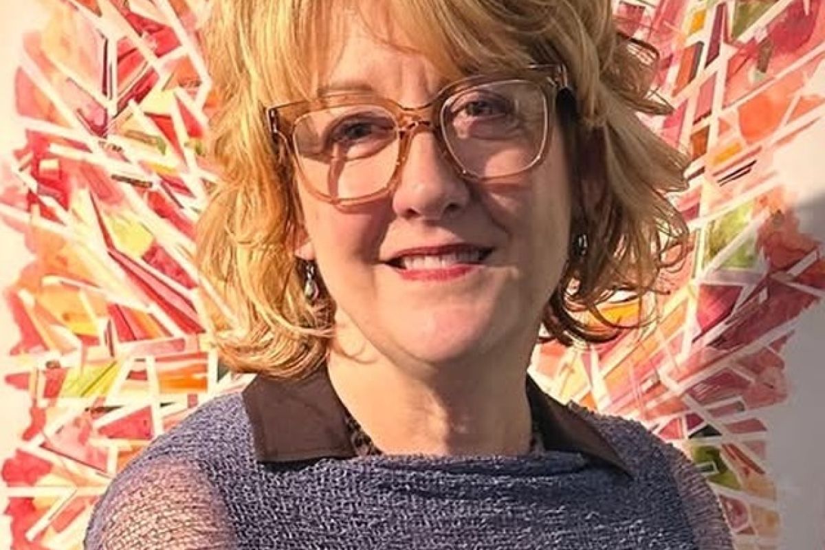 woman smiling in front of a painting