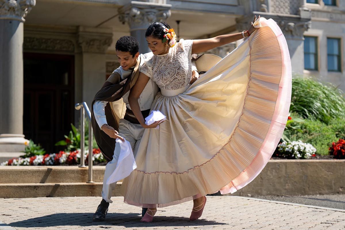 Emmy Gallegos dances with instructor Carlos Gallardo celebrating Peru's independence day at the state capitol in 2024