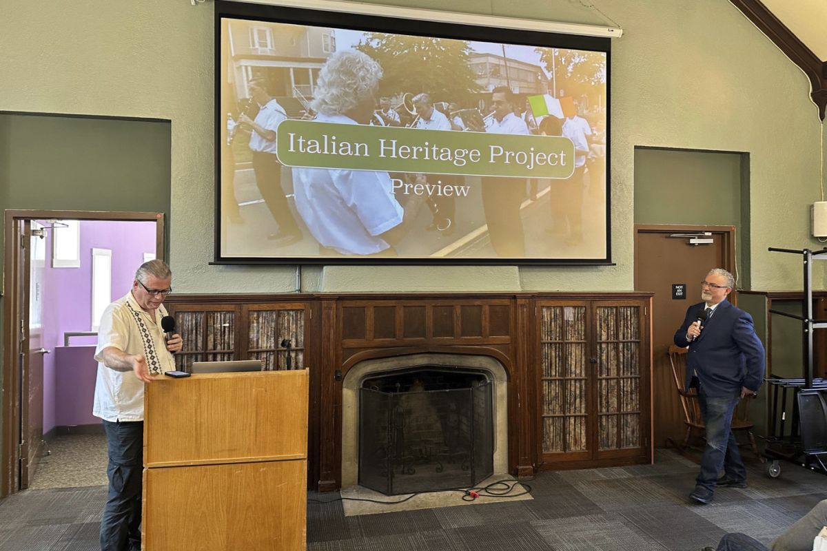 Large Screen on wall with two man standing before it