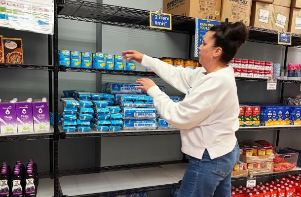 Courtney McDavid, the coordinator of CCSU's food pantry stocks the shelves filled with non-perishable items from Connecticut Foodshare. Connecticut Foodshare largely supports campus food pantries across the state. Credit: Sara Bedigian / CT Mirror