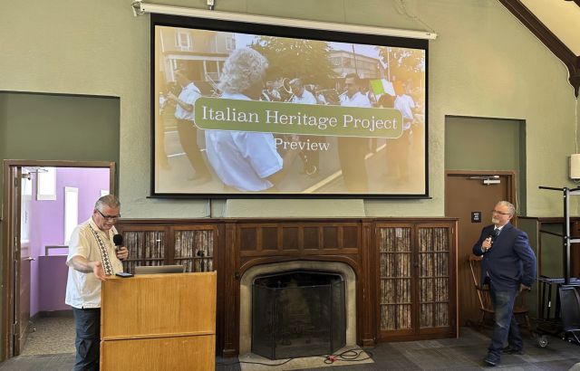 Large Screen on wall with two man standing before it