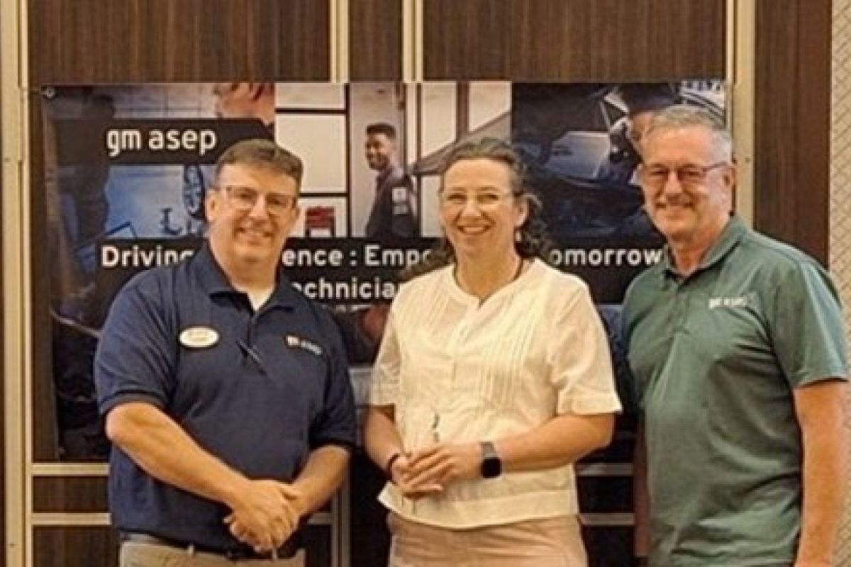 2 men and a woman stand together and smile into the camera