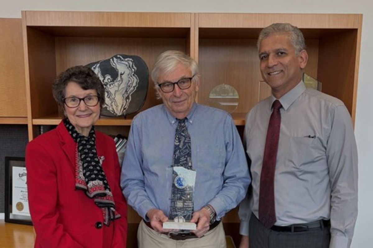 Jim Sherrard stands and smiles at the camera with the president and dean of academics