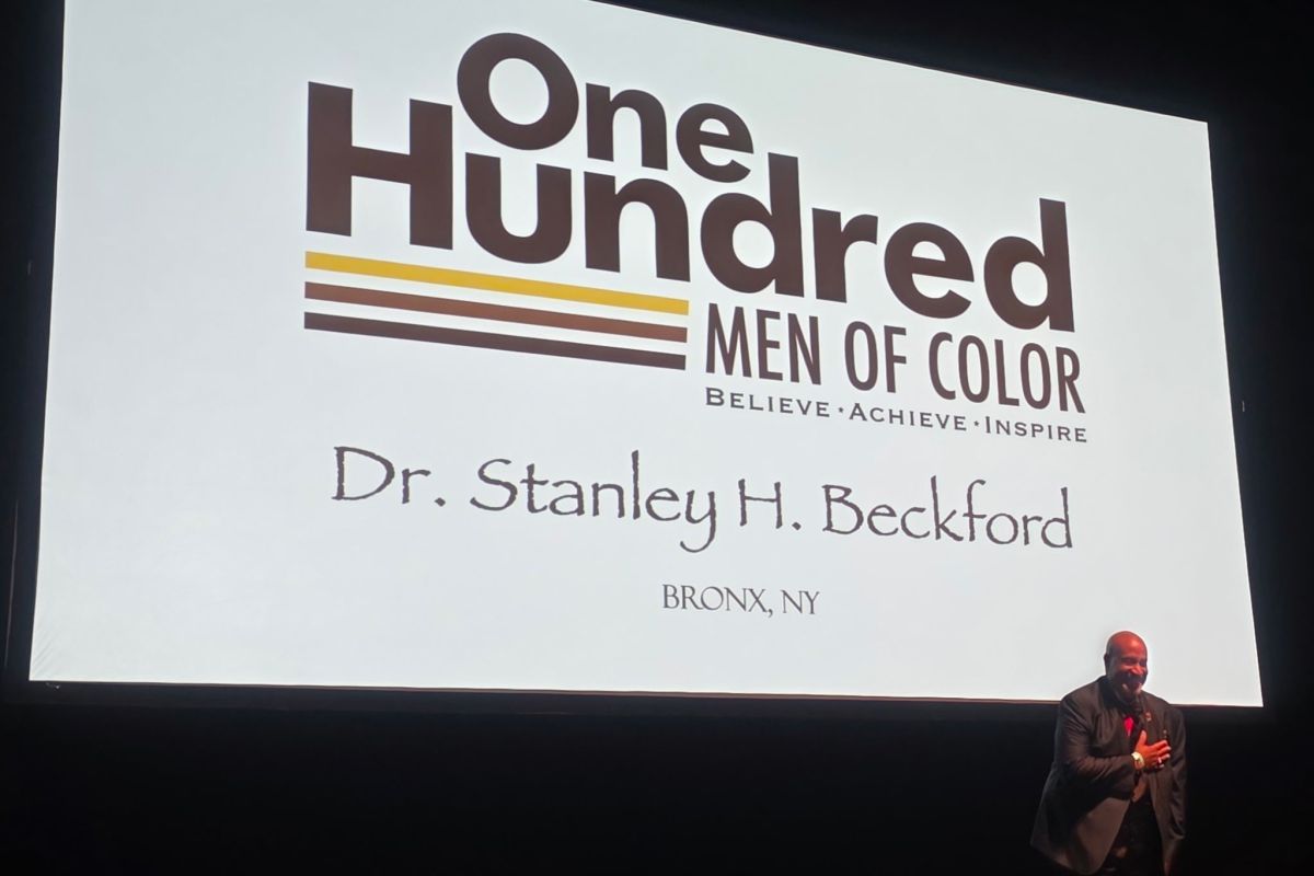 Man on stage in front of screen