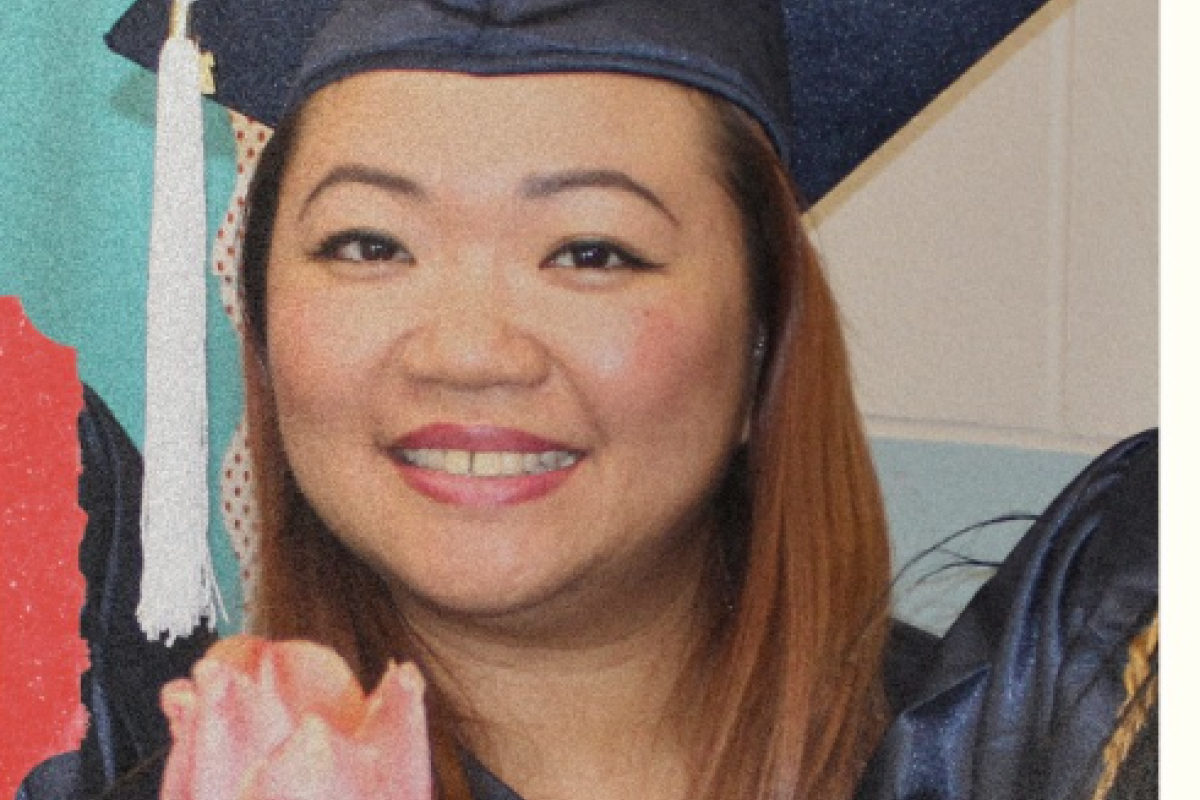 Asian woman smiles into camera wearing a graduation cap.